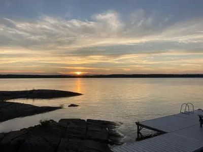 a sunset over a body of water with a dock at Genesis Voorschoten in Voorschoten