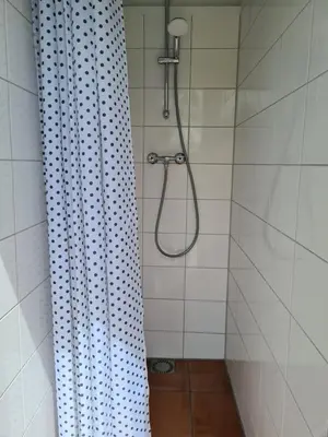 a shower with a shower curtain in a bathroom at B&B Beemsterlust in Westbeemster
