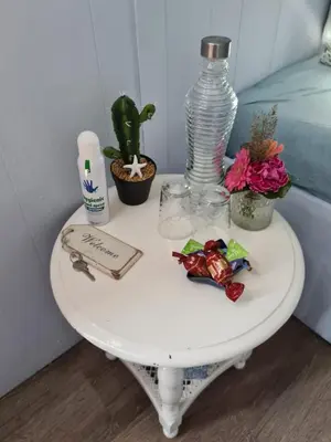 a white table with flowers and a bottle on it at B&B Beemsterlust in Westbeemster