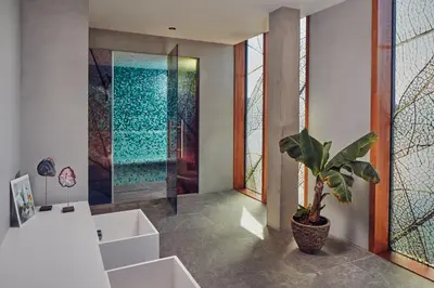 a bathroom with a shower and a potted plant at Hotel Jakarta Amsterdam in Amsterdam