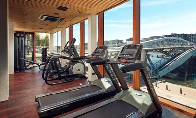 a gym with several cardio machines in a building at Hotel Jakarta Amsterdam in Amsterdam
