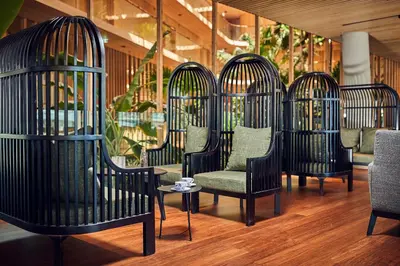 a row of bird cages with chairs and a table at Hotel Jakarta Amsterdam in Amsterdam