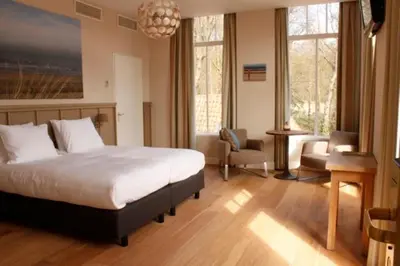 a bedroom with a bed and a desk and a chair at Loetje Overveen in Overveen