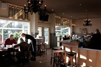 a woman standing at a bar in a restaurant at Loetje Overveen in Overveen