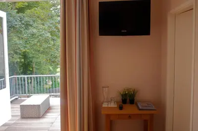 a living room with a television on the wall next to a balcony at Loetje Overveen in Overveen