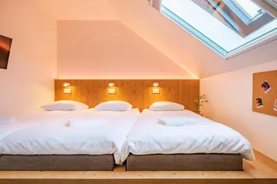 two beds in a bedroom with a skylight at Bunk Hotel Amsterdam in Amsterdam