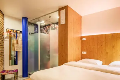 a bedroom with two beds and a glass shower at Bunk Hotel Amsterdam in Amsterdam