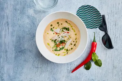 a bowl of soup on a table with a red pepper at Bunk Hotel Utrecht in Utrecht