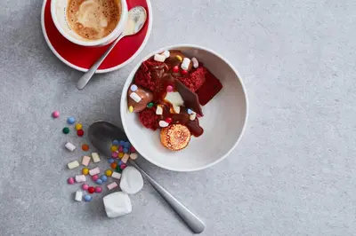 a plate of food with candy and a cup of coffee at Bunk Hotel Utrecht in Utrecht