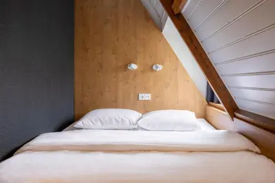 a bed with white sheets and pillows in a room at Bunk Hotel Utrecht in Utrecht
