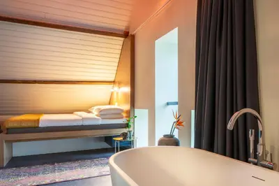 a bathroom with a tub and a bed at Bunk Hotel Utrecht in Utrecht