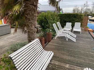a group of white chairs sitting on a wooden deck at Einzigartiges Haus am Isselmeer in Wervershoof