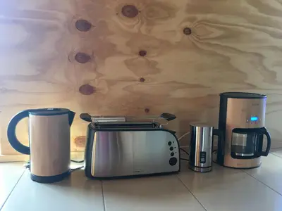 three coffees and a toaster on a kitchen counter at Einzigartiges Haus am Isselmeer in Wervershoof