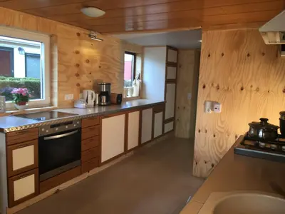 a kitchen with wooden walls and counters and a sink at Einzigartiges Haus am Isselmeer in Wervershoof