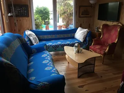 a living room with a blue couch and a table at Einzigartiges Haus am Isselmeer in Wervershoof