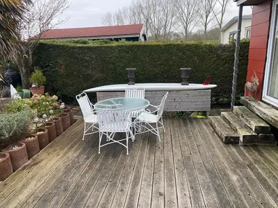 a patio with a table and chairs and a bath tub at Einzigartiges Haus am Isselmeer in Wervershoof