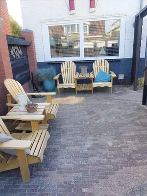 a patio with two chairs and a table and two chairs at De Kneet in Egmond aan Zee