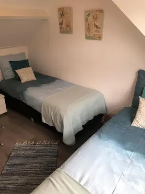 a bedroom with two beds and a rug at De Kneet in Egmond aan Zee