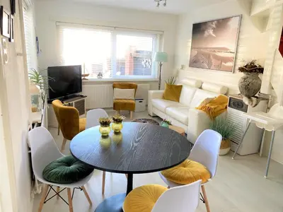 a living room with a table and chairs and a couch at De Kneet in Egmond aan Zee