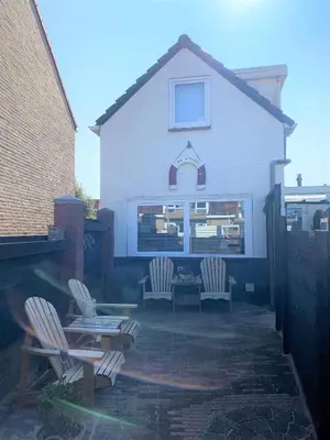a group of chairs and a table in front of a house at De Kneet in Egmond aan Zee