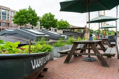 a picnic table and benches with an umbrella at B&B Vita Nova in Amersfoort