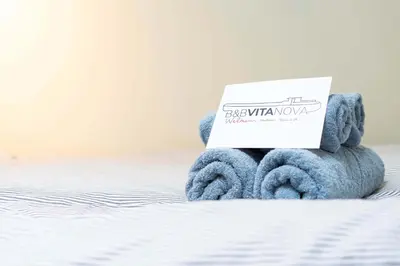 a teddy bear with a sign on its back on a bed at B&B Vita Nova in Amersfoort