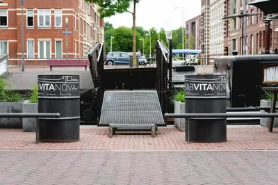 two trash cans sitting on a sidewalk next to a staircase at B&B Vita Nova in Amersfoort