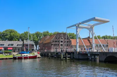 a bridge over a body of water with a boat at EuroParcs Markermeer in Bovenkarspel