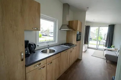 a kitchen with a sink and a window at EuroParcs Markermeer in Bovenkarspel