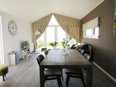 a living room with a table and a couch at EuroParcs Markermeer in Bovenkarspel