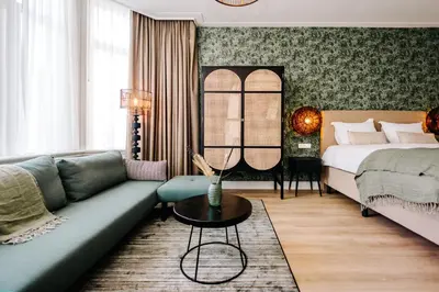 a living room with a couch and a bed at Boutique hotel Margretha in Zandvoort
