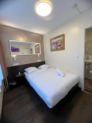 a bedroom with a large bed and a mirror at Dam Hotel in Amsterdam
