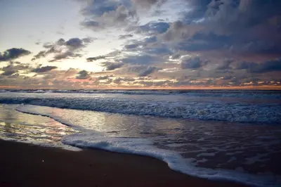a sunset on the beach with the ocean at Apartment Seastar Zandvoort in Zandvoort