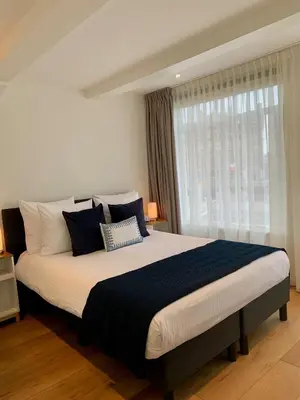 a bedroom with a large bed with blue and white pillows at PH93 Amsterdam Central in Amsterdam