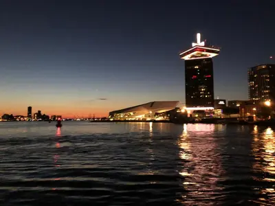 a view of a city at night from the water at PH93 Amsterdam Central in Amsterdam