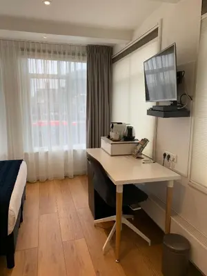 a hotel room with a desk and a bed at PH93 Amsterdam Central in Amsterdam