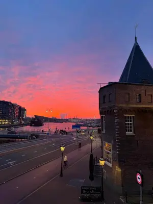 a sunset over a street with a building and a road at PH93 Amsterdam Central in Amsterdam
