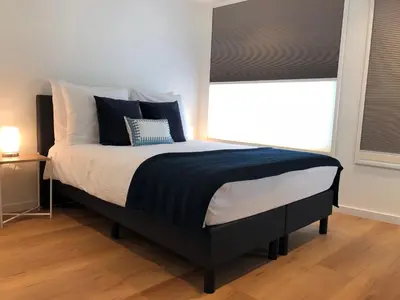 a bedroom with a bed with black and white sheets and a window at PH93 Amsterdam Central in Amsterdam