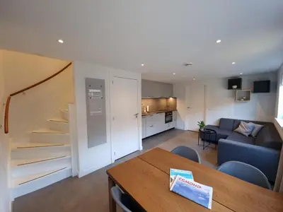 a living room with a table and a blue couch at Zomerhuis de Jong in Egmond aan Zee