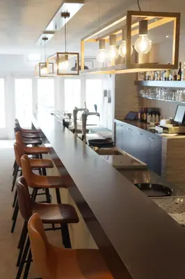 a kitchen with a long counter with a row of chairs at Landgoed ISVW in Leusden