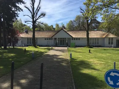 a white building with trees in front of it at Landgoed ISVW in Leusden
