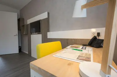 a kitchen with a desk with a phone and a yellow chair at Landgoed ISVW in Leusden