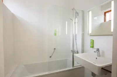 a white bathroom with a shower and a sink at Landgoed ISVW in Leusden