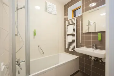 a bathroom with a bath tub and a sink at Landgoed ISVW in Leusden