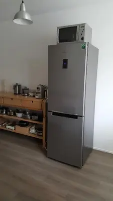 a refrigerator with a microwave on top of it in a kitchen at Quiet spacious room in Amsterdam