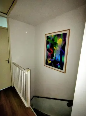 a hallway with a painting on the wall at Quiet spacious room in Amsterdam