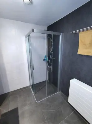 a bathroom with a shower with a glass door at Quiet spacious room in Amsterdam