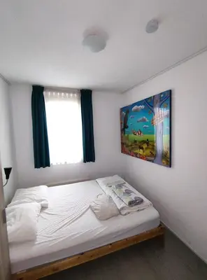 a bedroom with a bed with a painting on the wall at Quiet spacious room in Amsterdam