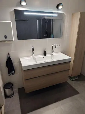 a bathroom with a white sink and a mirror at Quiet spacious room in Amsterdam