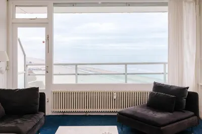 a living room with a couch and a large window at De Steltloper in Zandvoort